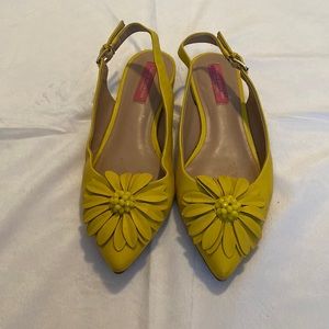 Yellow leather strappy slides with flower accent.